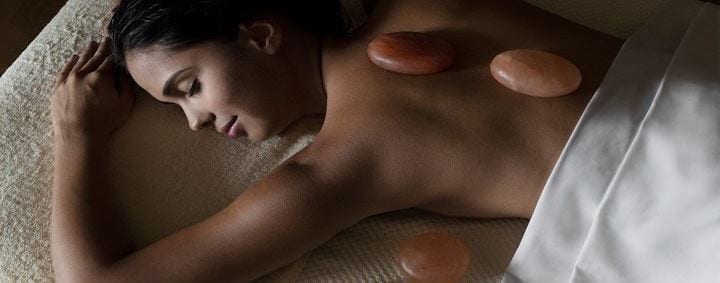 A woman relaxes with hot stones placed on her back during a soothing massage at Shangri-La Hotel